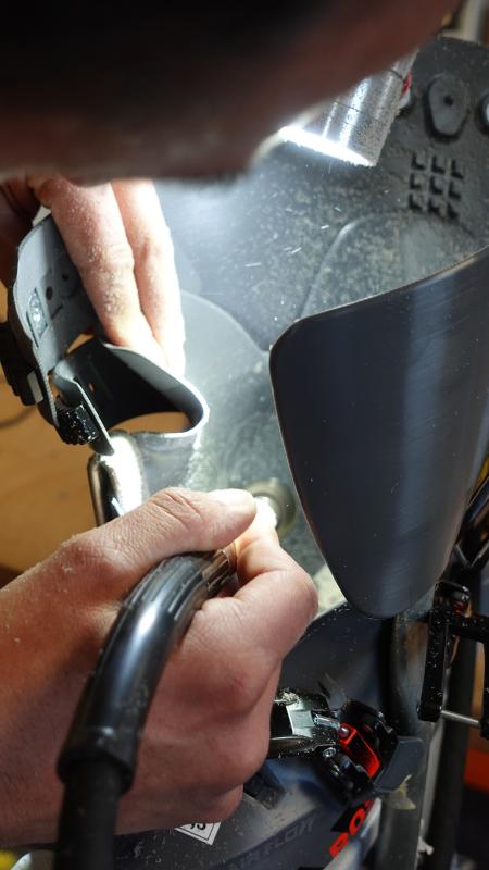 A bootfitter grinding a ski shoe